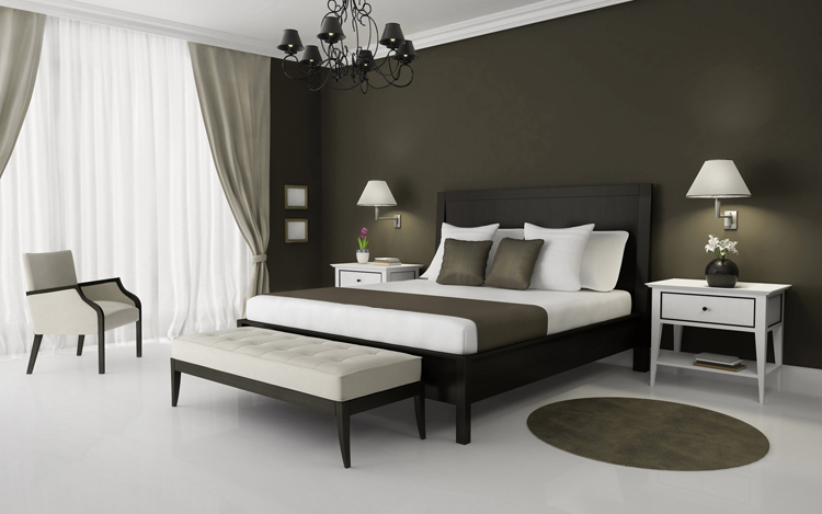 Bear mattress with bedspread in bedroom with night table and lamp.